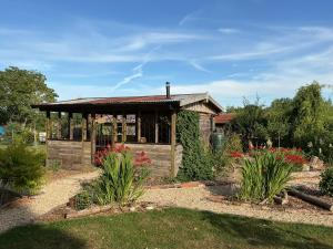 a small wooden building with flowers in a garden at The Cosy Nest Hut in Keddington