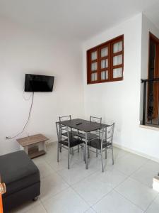 a dining room with a table and chairs and a tv at casa fresh in Rodadero