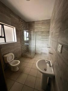 ein Badezimmer mit Toilette und Waschbecken in der Unterkunft Grand Inn Hotel-Venda in Thohoyandou