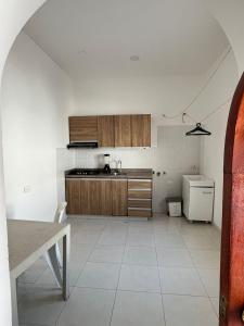 a kitchen with wooden cabinets and a white tile floor at casa fresh in Rodadero