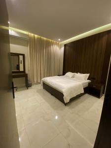 a bedroom with a bed with a wooden headboard at albaha harmony resort in Al Baha