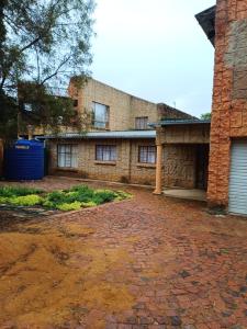 een bakstenen gebouw met een garage en een stenen oprit bij Bush and Birding Backpacker in Pretoria