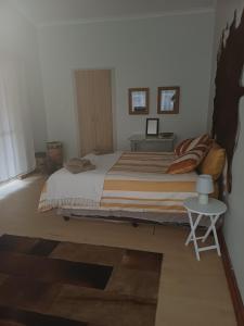 een slaapkamer met een groot bed en een tafel bij Bush and Birding Backpacker in Pretoria