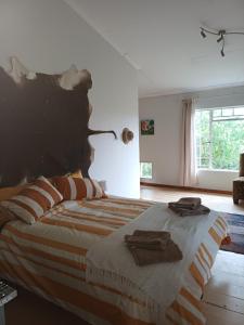een slaapkamer met een bed met twee handdoeken erop bij Bush and Birding Backpacker in Pretoria