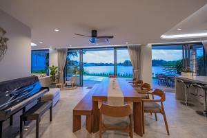 a living room with a long wooden table and chairs at Lakeside 5-BR New Pool Villa in Gated Community in Chalong 