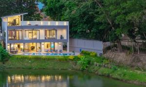 a house with a river in front of it at Lakeside 5-BR New Pool Villa in Gated Community in Chalong 