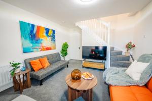 un salon avec un canapé et une télévision dans l'établissement Spacious & High celling 2 Bedroom House, à Cardiff