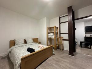 Un dormitorio con una cama y una silla y un televisor. en Le Cocon Cathédrale, en Metz