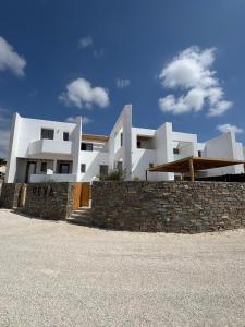 艾丽奇REYA suites的前面有石墙的白色房子