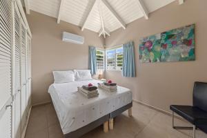 a bedroom with a bed with white sheets and a window at 6 persoons vakantiehuis in Jan Thiel in Willemstad +20 photos