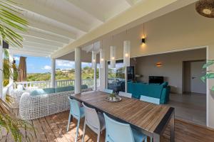 a dining room and living room with a table and chairs at 6 persoons vakantiehuis in Jan Thiel in Willemstad