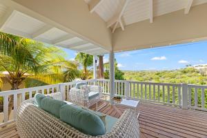 a porch with wicker chairs on a wooden deck at 6 persoons vakantiehuis in Jan Thiel in Willemstad