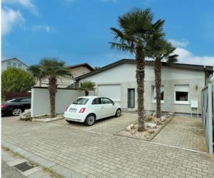 a white car parked in front of a house with palm trees at Speyer Ferienwohnung Apartment 5 in Speyer