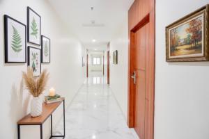 un couloir avec des murs blancs et une porte en bois dans l'établissement FabHotel Radha Rani Residency, à Khammam