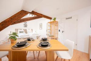 a dining room with a wooden table and chairs at LudwigsCozyEscape - Historisches Altstadt-Apartment mit Sichtbalken am Residenzschloss, 6 Gäste, SmartTV in jedem Zimmer, Highspeed WLAN, Workspace, 24h Self Check-in, Parkhaus 2 Min Gehweite in Ludwigsburg