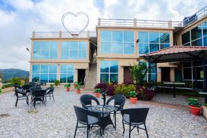 a building with chairs and a table and a heart balloon at Tulips Valley View Resorts in Ooty