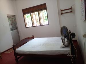 - une chambre avec un lit et un ventilateur dans l'établissement Happy villa, à Weligama