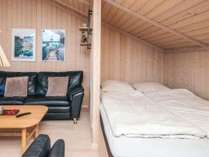 ein Zimmer mit einem Bett, einer Couch und einem Tisch in der Unterkunft 8 person holiday home in Ebeltoft-By Traum in Ebeltoft