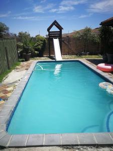una gran piscina azul con un tobogán en un patio en Amery Villa, en Gqeberha