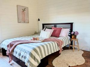 une chambre avec un lit avec une couverture rayée dans l'établissement Hanging Rock Farm Stay, à Newham