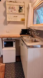 une petite cuisine avec un évier et un micro-ondes dans l'établissement Hanging Rock Farm Stay, à Newham 14 autres photos