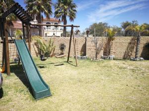 un parque infantil con un tobogán verde en un patio en Amery Villa, en Gqeberha