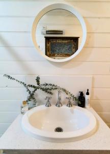 un lavabo de salle de bain avec un miroir au-dessus dans l'établissement Hanging Rock Farm Stay, à Newham