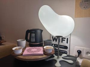 une table avec une lampe et deux tasses de café dans l'établissement Kosy Suite, à Saint-Aubin-du-Cormier