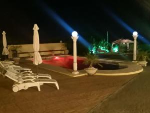 un gruppo di sedie e una piscina di notte di Villa Roca - 1st floor a Estepona