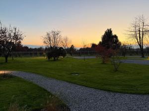 a park at sunset with a path in the grass at Agriturismo Il Ceraseto da Tomasi in San Biagio di Callalta