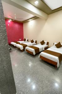 Una fila de cuatro camas en una habitación en JD Bro Inn, en Sheoganj 7 fotos más
