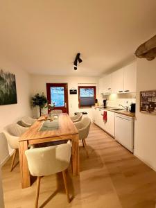 a kitchen and dining room with a wooden table and chairs at Ferien im Schwarzwald Dörlinbach II in Schuttertal