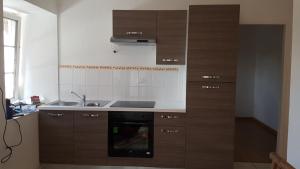 una cucina con mobili in legno e un lavello di L'écrin de l'abreuvoir a Marnay