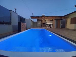a large blue swimming pool on the roof of a house at Casa Com Quatro Dormitórios, Pertinho Do Mar Em Capão Da Canoa in Capão da Canoa +70 photos