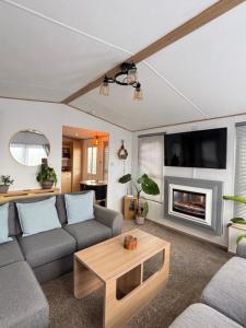 a living room with a couch and a fireplace at Seven Bays Hideaway in St Merryn