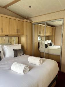 a bedroom with two beds and a mirror at Seven Bays Hideaway in St Merryn