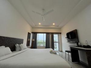 HatikhuliSneha Bhawan Kaziranga的一间带大床和电视的大卧室 更多31张照片