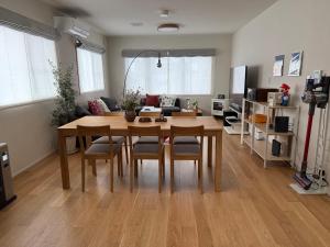 a living room with a wooden table and chairs at Mori Sapporo in Sapporo