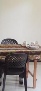 a table with two chairs and a table with plates on it at Yasiru Villa in Weligama +14 photos