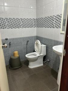 a bathroom with a toilet and a sink at Hotel caveri comfort in Madikeri