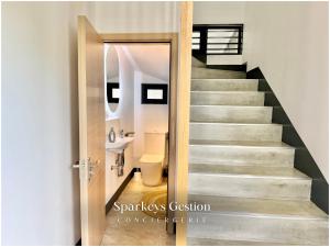 a bathroom with a toilet and a staircase at SG19 Villa Serenity Lux in Calodyne