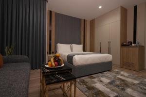 a hotel room with a bed and a bowl of fruit on a table at Quaint Hotel Erbil in Erbil +37 photos