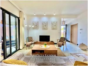 a living room with a couch and a table at SG19 Villa Serenity Lux in Calodyne +41 photos