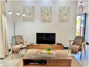 sala de estar con TV y 2 sillas en SG19 Villa Serenity Lux, en Calodyne