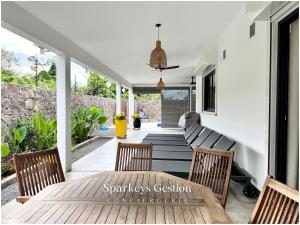 Un patio con una mesa y sillas en un porche. en SG19 Villa Serenity Lux, en Calodyne