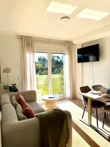 a living room with a couch and a large window at Apartamento Estudio con Wifi, Piscina y Parking in Sanxenxo +8 photos