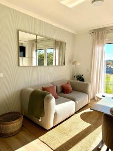 a living room with a couch and a mirror at Apartamento Estudio con Wifi, Piscina y Parking in Sanxenxo