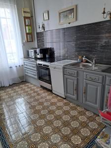 a kitchen with stainless steel appliances and a tile floor at Maison Charmante in Vervins