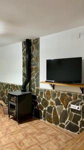Zimmer mit einer Steinmauer und einem Flachbild-TV in der Unterkunft Casa MªÁngeles in Puebla de Arenoso + 35 Fotos