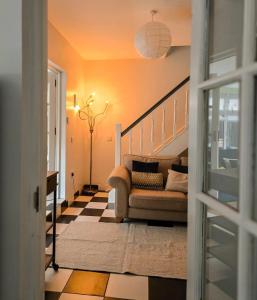 a living room with a couch and a staircase at The Big Belfast House Modern 6 Bedroom Townhouse in the Gaeltacht Quarter in Belfast